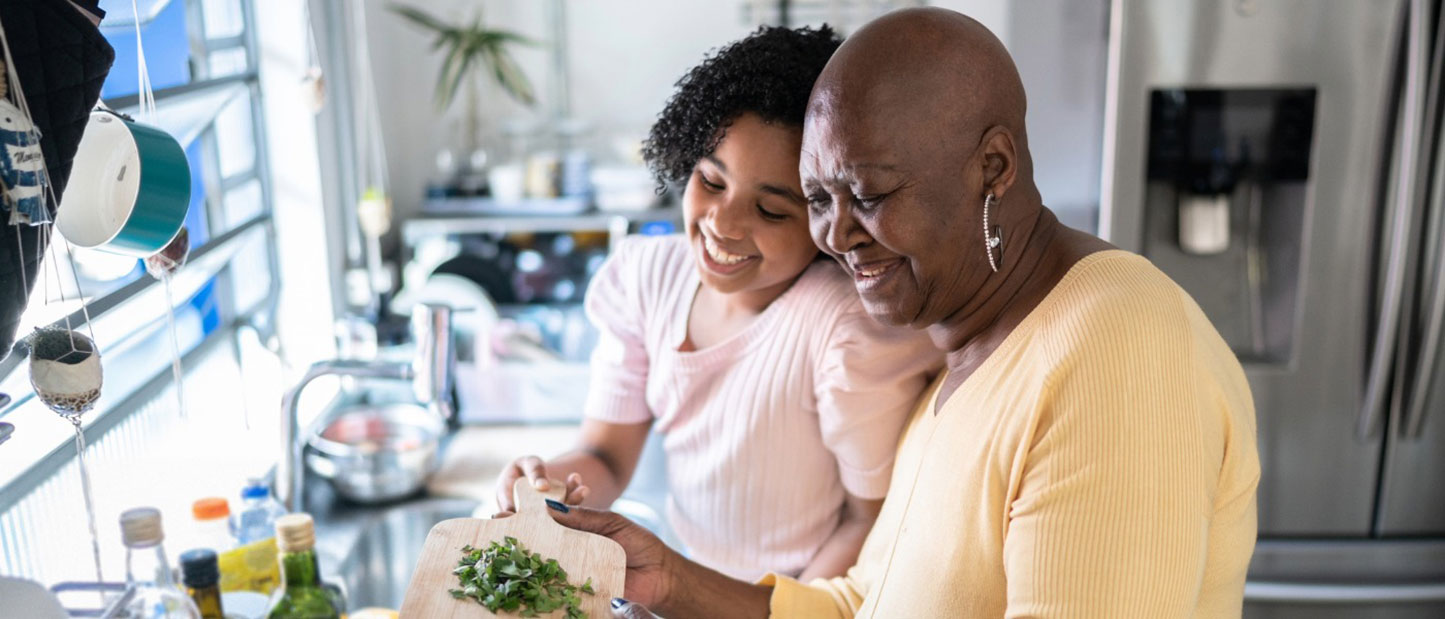 Girl helping grandmother cooking at home
