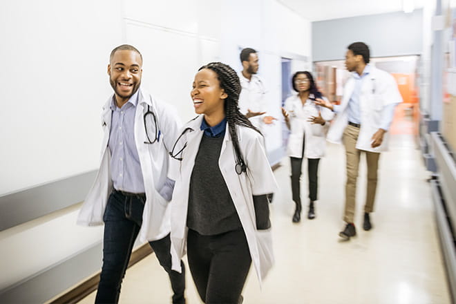 group of doctors walking down hospital hallway